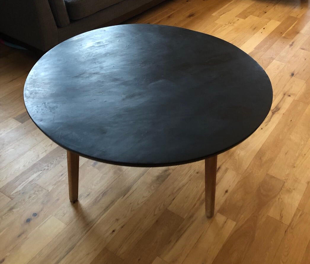 Round wooden table with a dark top and natural wood legs
